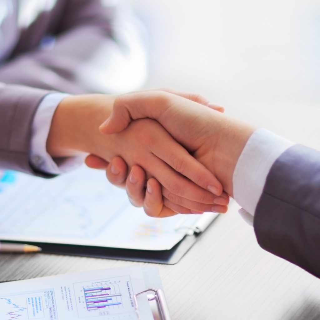 Duas pessoas apertando as mãos.